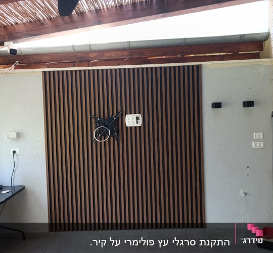 קיר עם חיפוי עץ ומתקן לטלוויזיה